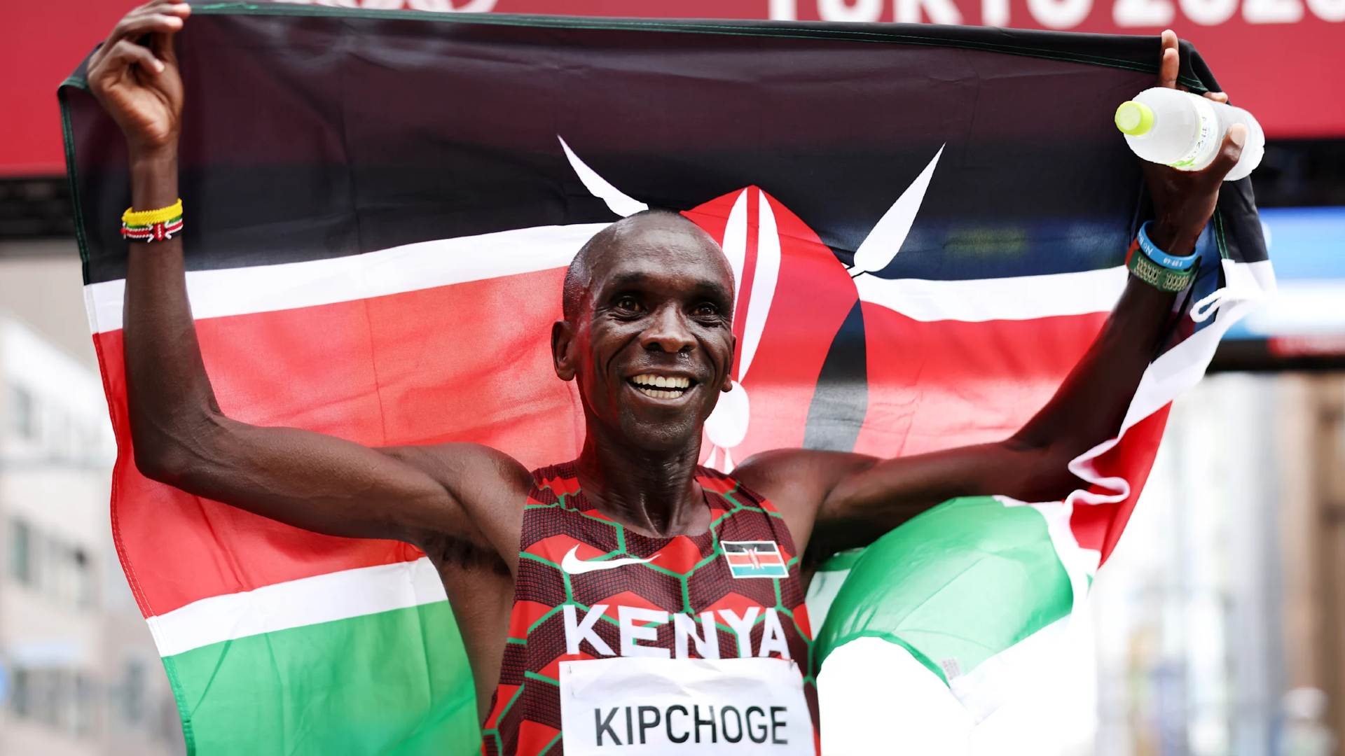 Eliud Kipchoge holding the Kenyan flag after winning the Tokyo 2020